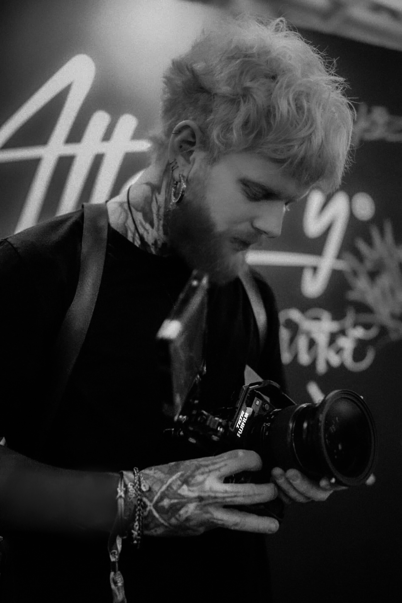 Lug, filmmaker behind Brazil Calling, holding a camera at a tattoo event